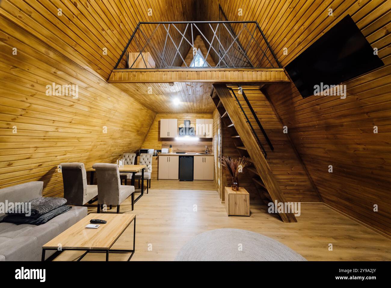 Cabina interna moderna in legno con cucina e zona loft, perfetta per rilassarsi e rifugi accoglienti Foto Stock