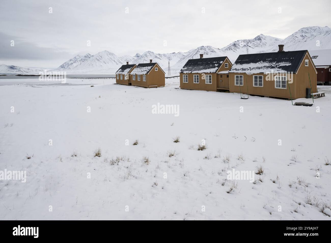 Case color ocra, insediamento di ricerca, insediamento scientifico, paesaggio montano invernale, NY-Alesund, Kongsfjord, Spitsbergen Island, Svalbard AN Foto Stock