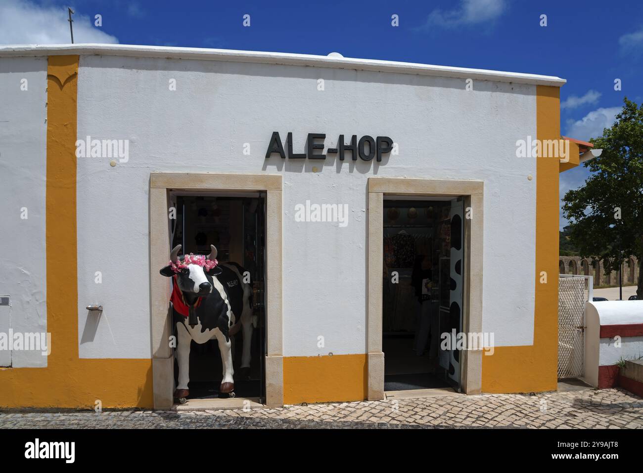 Fai shopping di fronte con un'accattivante decorazione di mucche in plastica sotto un cielo blu, Obidos, Obidos, Oeste, Centro, Estremadura, Portogallo, Europa Foto Stock