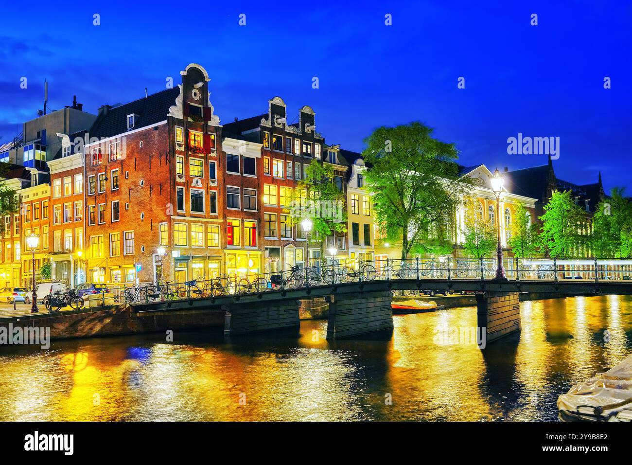 Famoso fiume Amstel e vista notturna della bellissima città di Amsterdam. Paesi Bassi Foto Stock