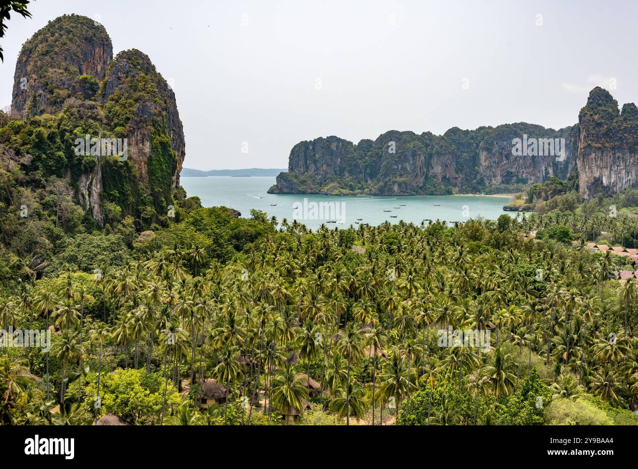 Laguna di spiaggia circondata da una fitta foresta alberata con montagne rocciose in Thailandia Foto Stock