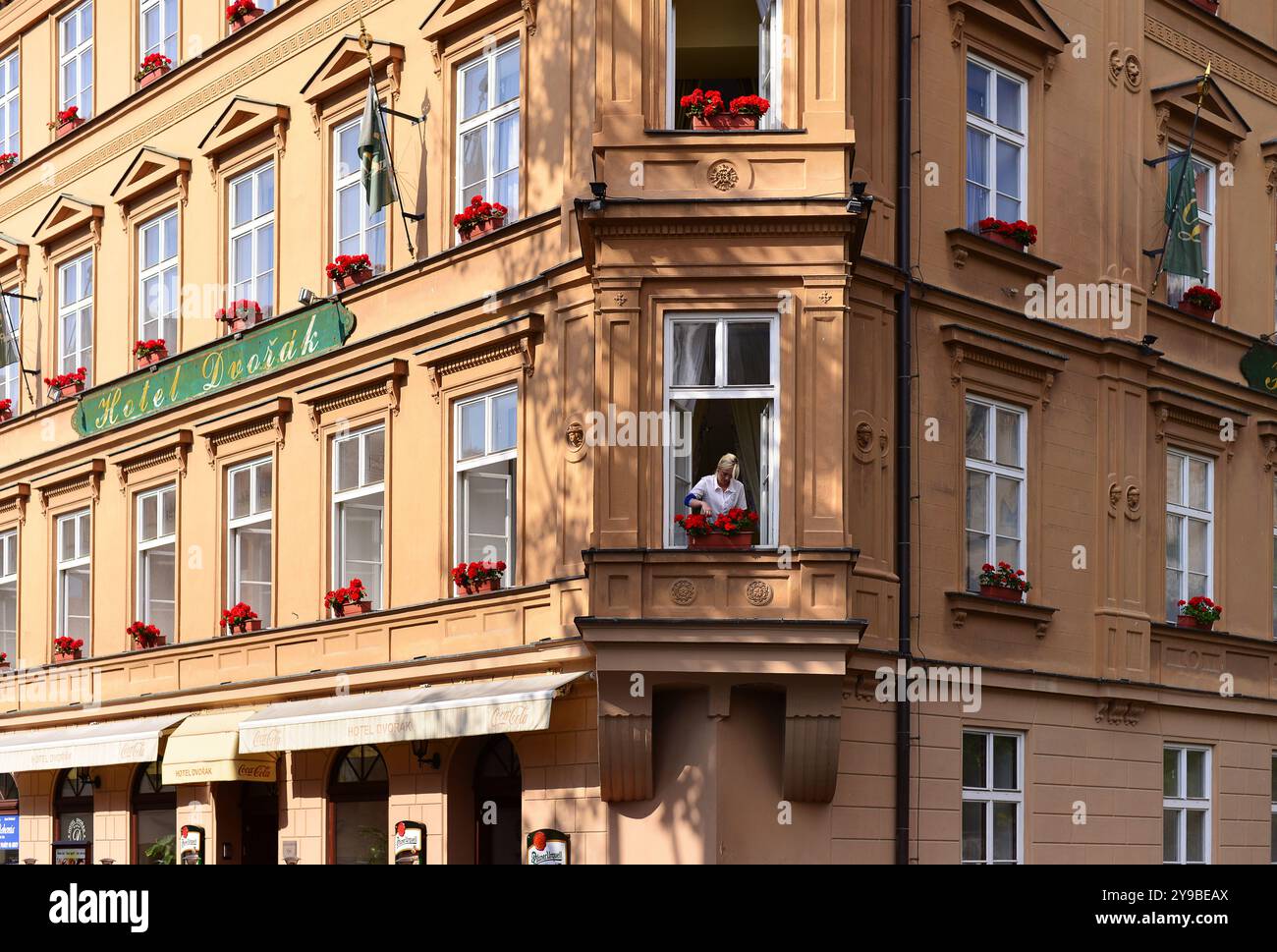 Una persona che innaffia i fiori nella finestra dello storico Hotel Dvorak Cesky Krumlov, Repubblica Ceca Foto Stock