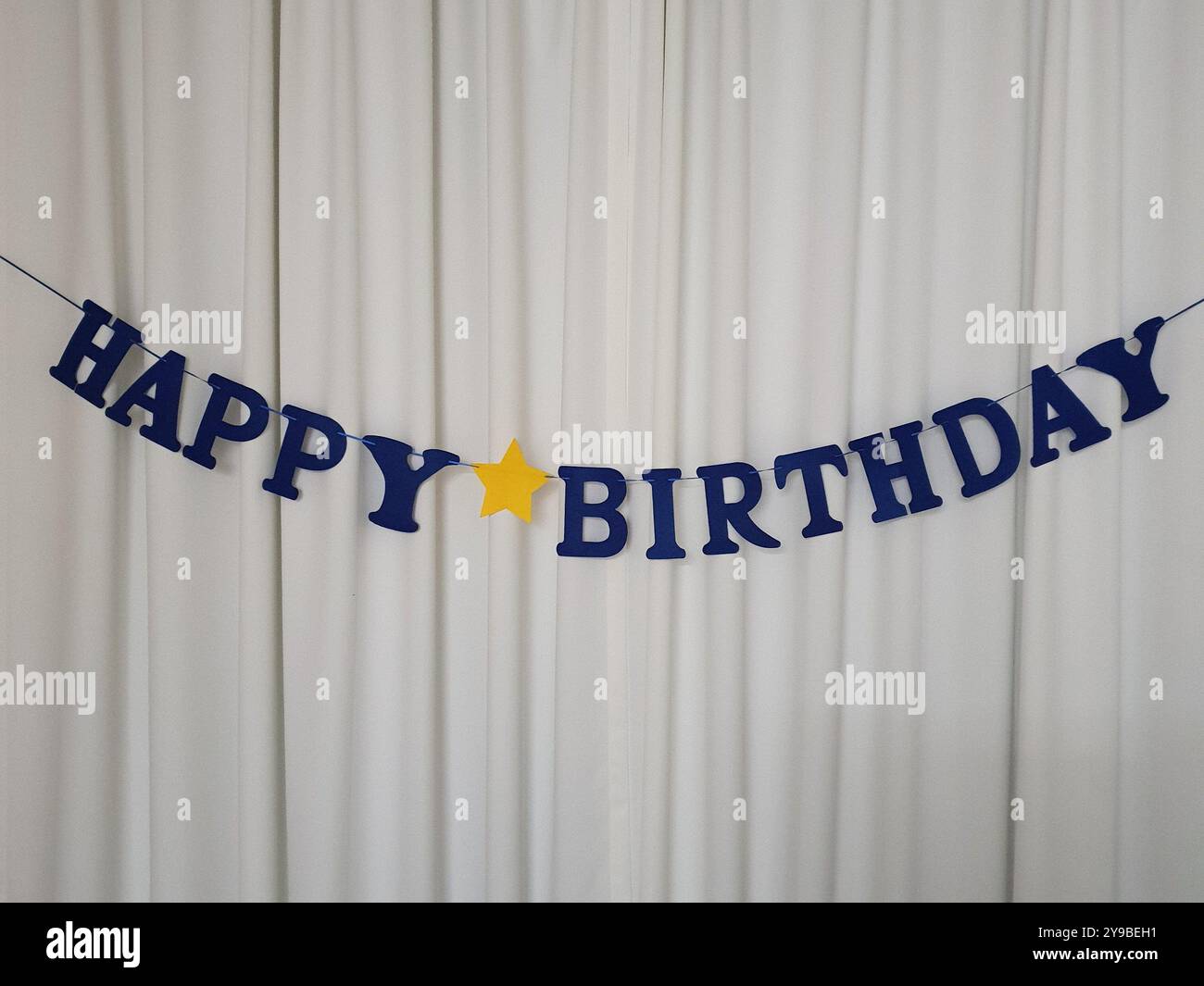Una foto dell'evento con un messaggio di buon compleanno su una tenda bianca - Immagine stock catturata con smartphone