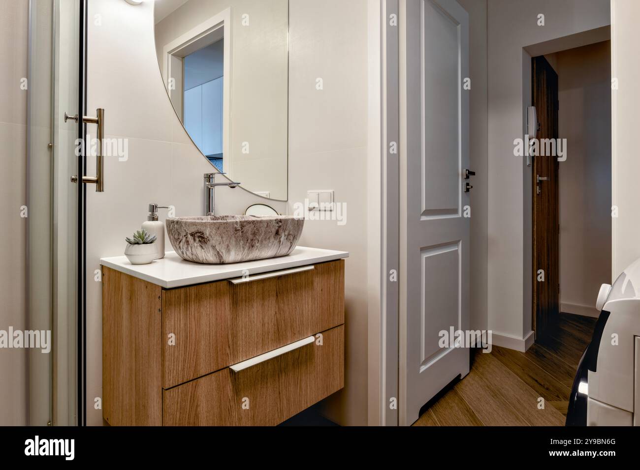 Un bagno moderno ed elegante con arredi eleganti e splendidi elementi in legno naturale Foto Stock
