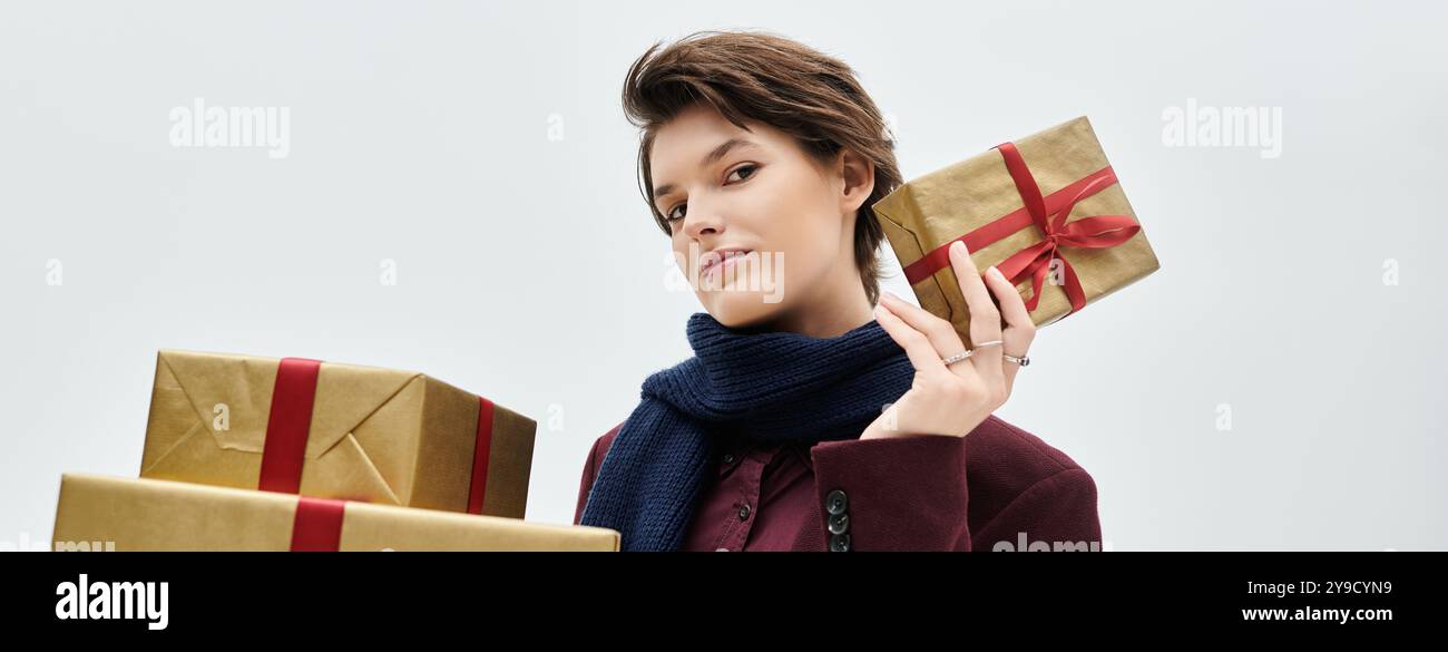 Avvolto in un'eleganza accogliente, una donna mostra il suo spirito festivo mostrando regali di stagione. Foto Stock
