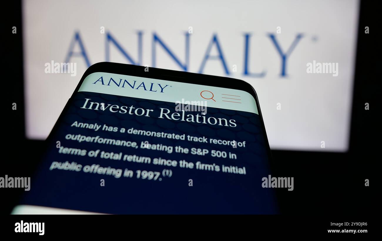 Telefono cellulare con sito web della società statunitense Annaly Capital Management Inc. Sullo schermo di fronte al logo aziendale. Mettere a fuoco in alto a sinistra sul display del telefono. Foto Stock