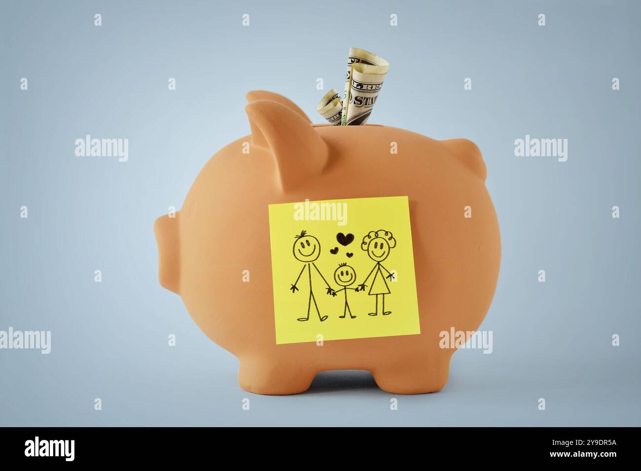 Salvadanaio con famiglia di disegno su un biglietto adesivo - concetto di finanze di famiglia Foto Stock