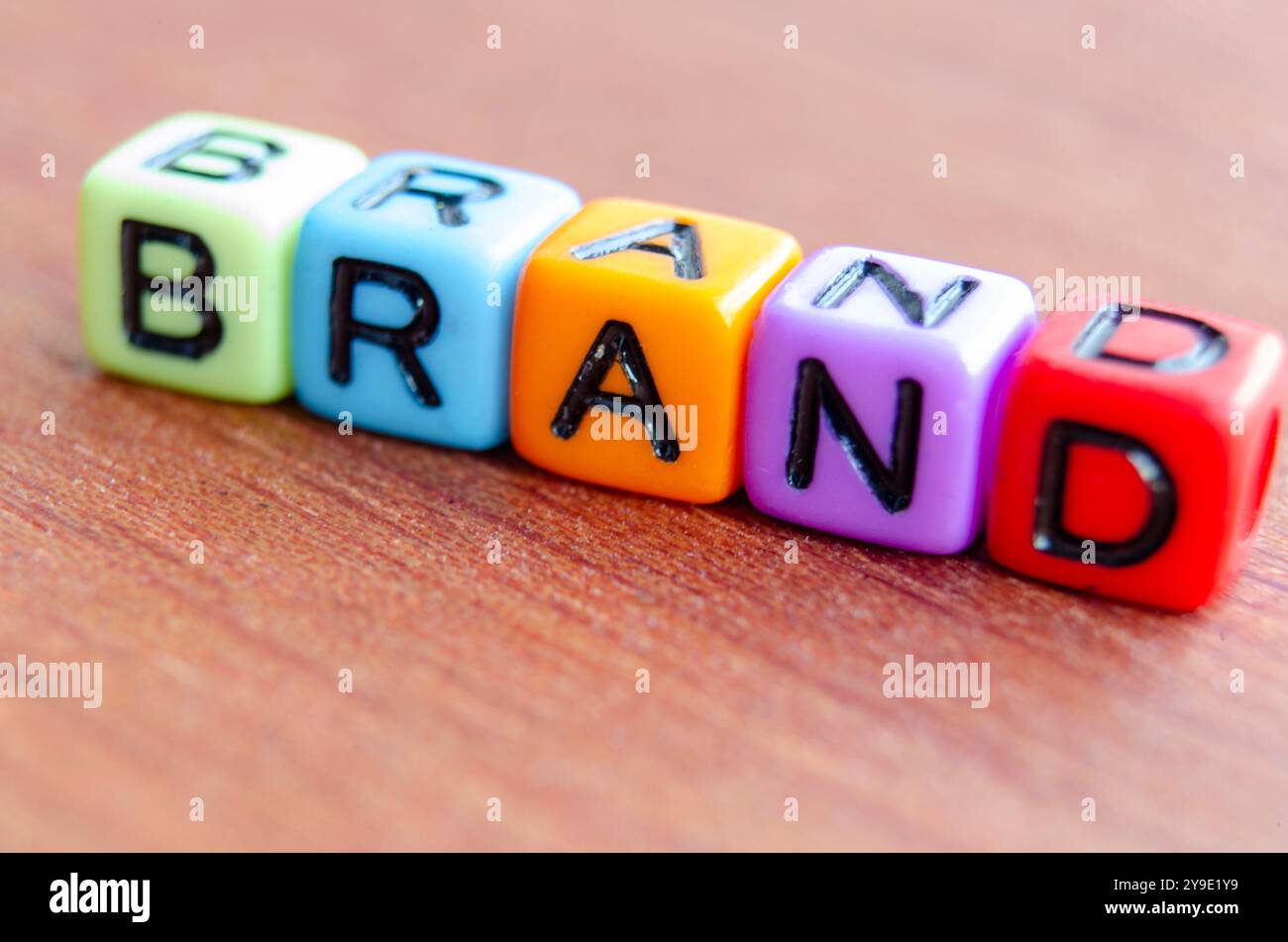 Cubi multicolore con testo del marchio su un tavolo in legno. Foto Stock