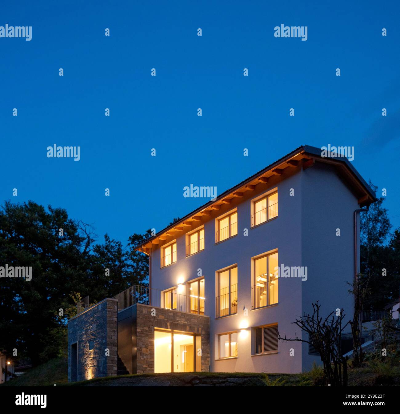 Casa indipendente appena rinnovata, con finiture moderne. Retro della casa con ampio giardino verde privato. Scena notturna, nessuno dentro Foto Stock Casa indipendente appena rinnovata, con finiture moderne. Retro della casa con ampio giardino verde privato. Scena notturna, nessuno dentro Foto Stock
