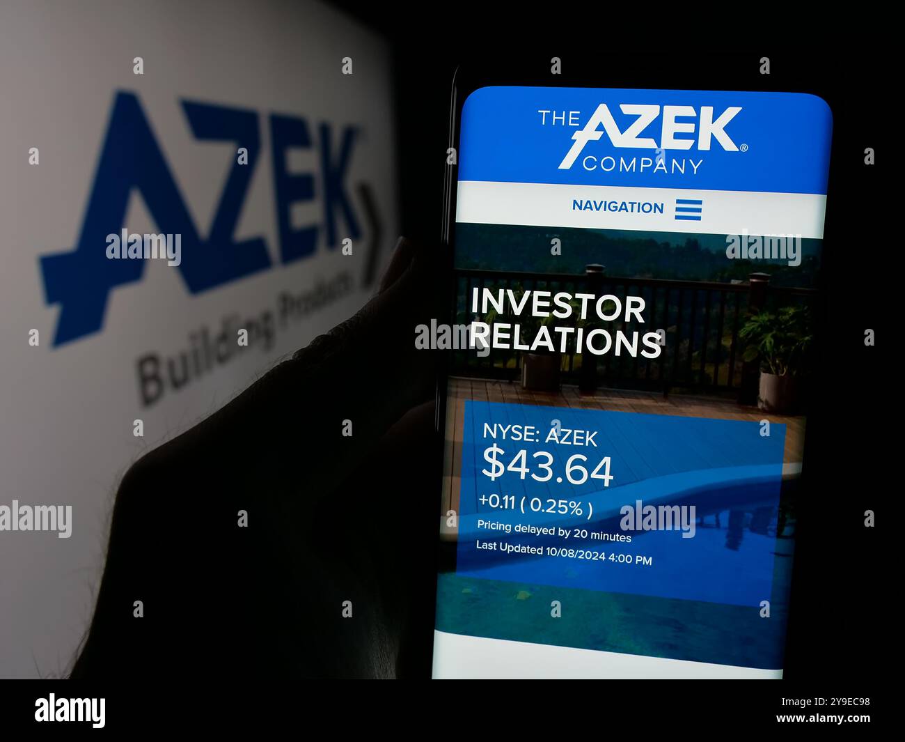 Persona che detiene lo smartphone con la pagina Web della società statunitense di prodotti per esterni Azek Company Inc. Sullo schermo con logo. Messa a fuoco al centro del display del telefono. Foto Stock