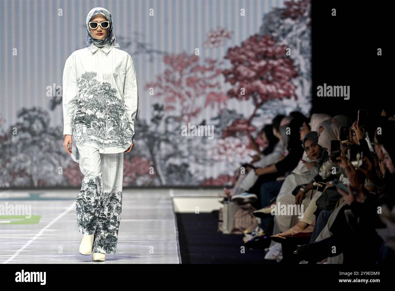 Tangerang, Indonesia. 10 ottobre 2024. Un modello presenta una creazione di Benang Jarum durante la Giacarta Muslim Fashion Week (JMFW) 2025 a Tangerang, provincia di Banten, Indonesia, il 10 ottobre 2024. Crediti: Agung Kuncahya B./Xinhua/Alamy Live News Foto Stock