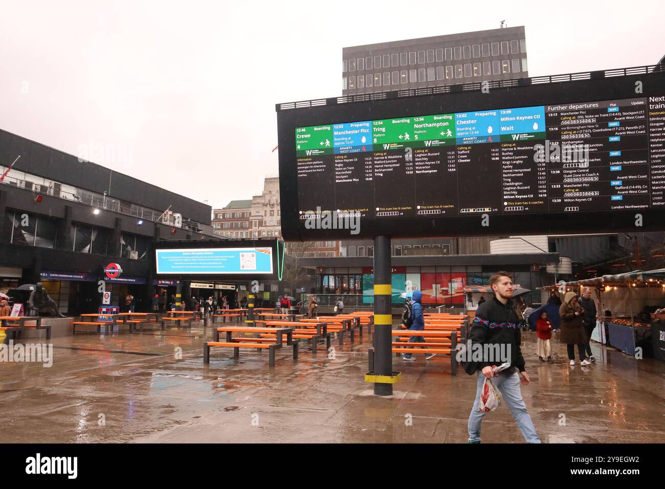 Londra Inghilterra Regno Unito 13 febbraio 2024 passeggeri alla stazione ferroviaria di Londra Euston che visualizzano gli schermi del sistema di informazione clienti (CIS). La stazione subisce una notevole congestione e sovraffollamento dei passeggeri. Per cercare di alleviare questo problema di sicurezza, le schermate nell'area verranno sostituite. La stazione è gestita da Network Rail ©Ged Noonan/Alamy Foto Stock