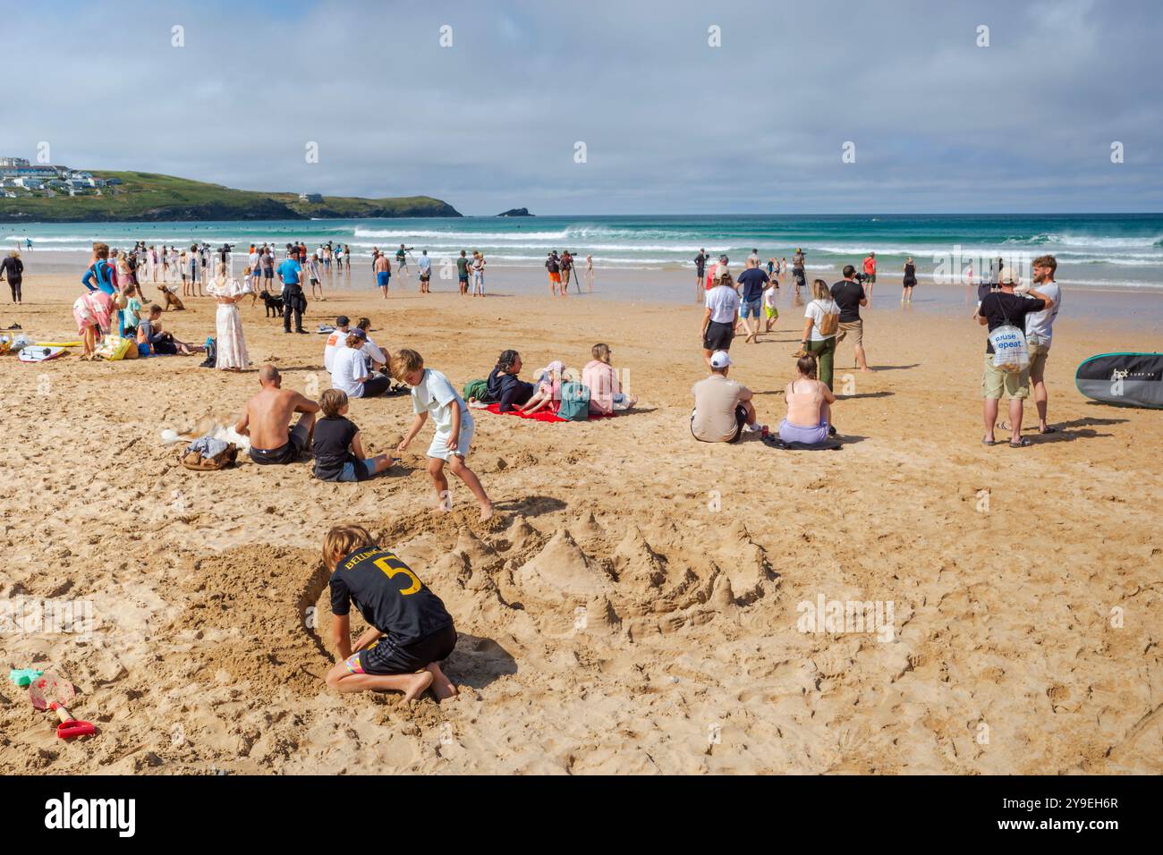 Turisti che si godono il sole estivo sull'iconica spiaggia Fistral di Newquay, in Cornovaglia, nel Regno Unito. Foto Stock