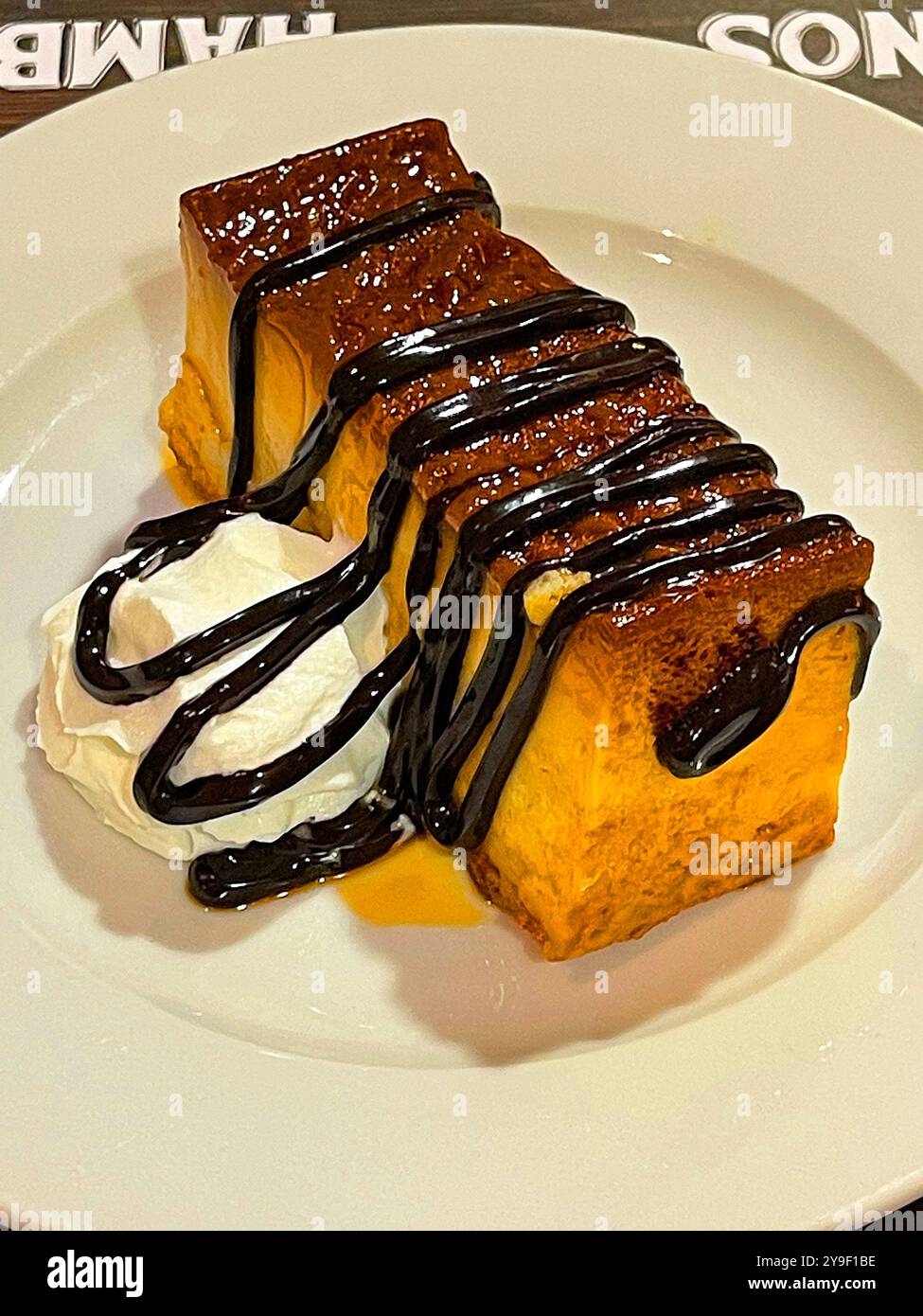 Budino con sciroppo al cioccolato e panna. Spagna. - Immagine stock catturata con smartphone