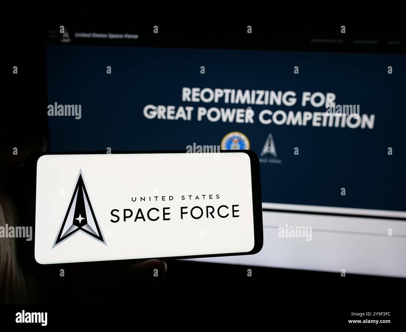 Persona con smartphone con logo della United States Space Force (USSF) sullo schermo di fronte al sito Web. Mettere a fuoco il display del telefono. Foto Stock