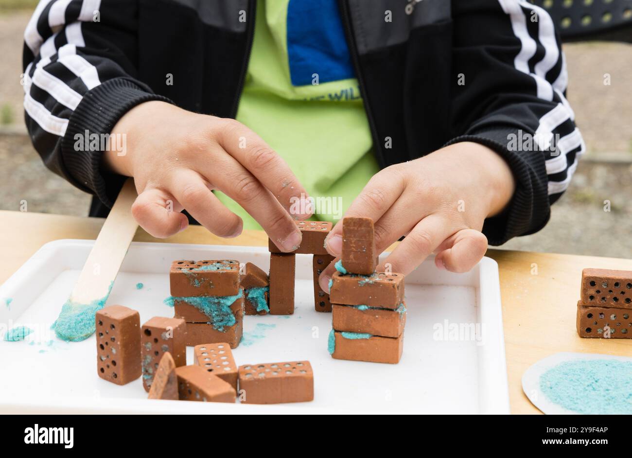 Edificio per bambini che crea un muro in mattoni in miniatura utilizzando tecniche di conservazione, Regno Unito. Foto Stock
