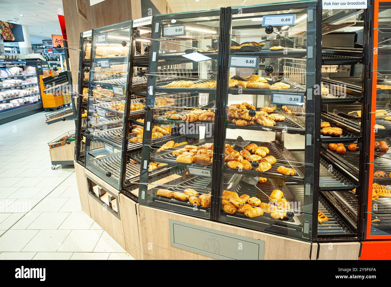 Diversi tipi di pasticceria e panini al forno in una vitrina in un supermercato dove i clienti possono scegliere e prendere i propri. Foto Stock