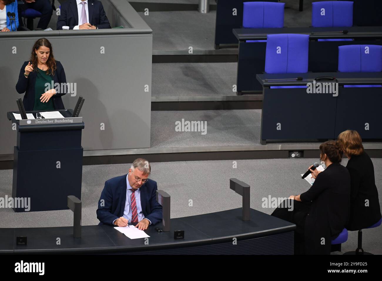 Berlino, Germania. 10 ottobre 2024. Heike Heubach (SPD, l), il primo membro sordo del Bundestag, tiene un discorso nel Bundestag. Seduti di fronte a lei ci sono i suoi due interpreti. Crediti: Carla Benkö/dpa/Alamy Live News Foto Stock