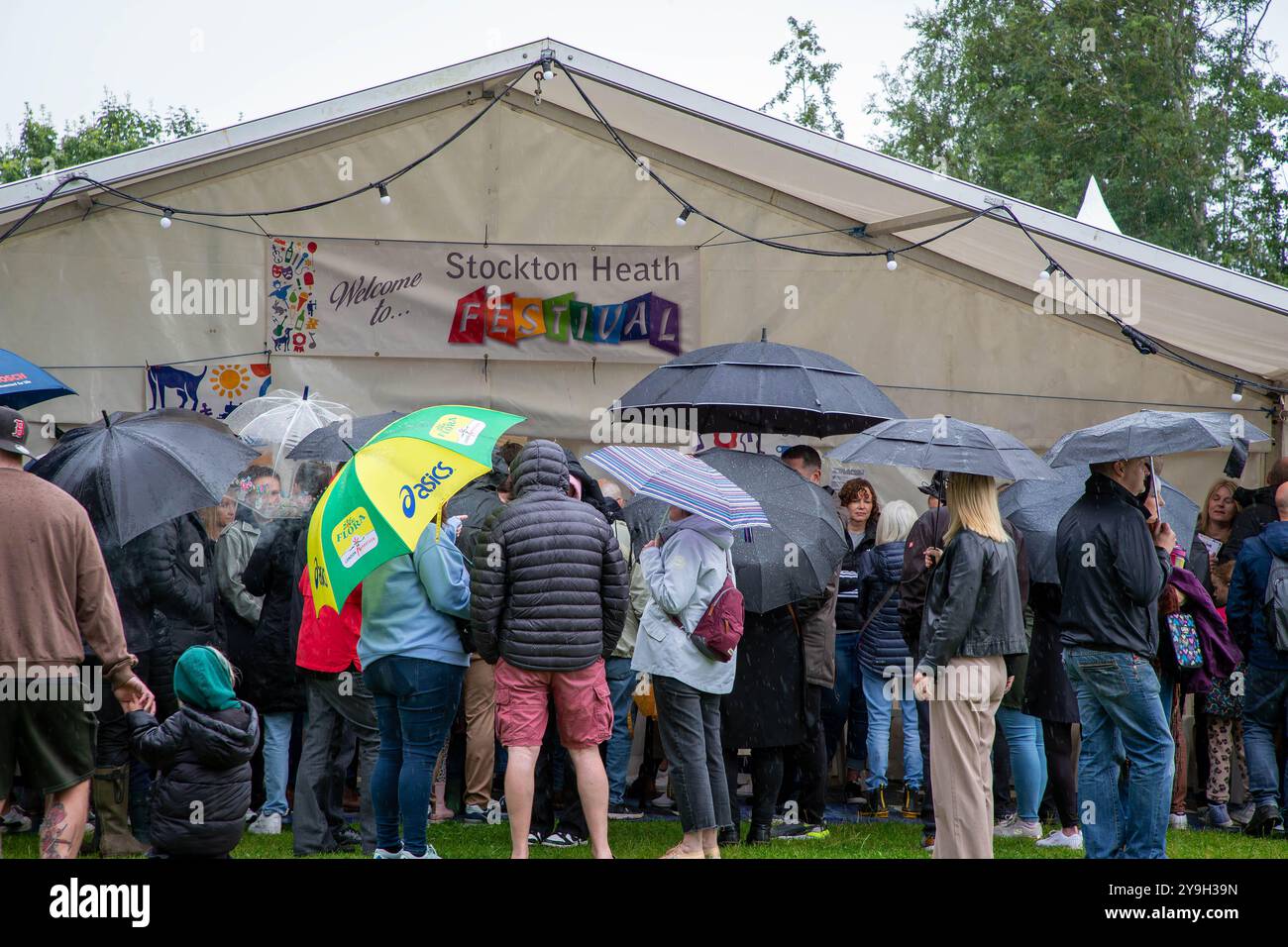 Folla di persone che rinuncia sotto la pioggia per l'apertura del tendone al 2024 Stockton Heath Festival Foto Stock