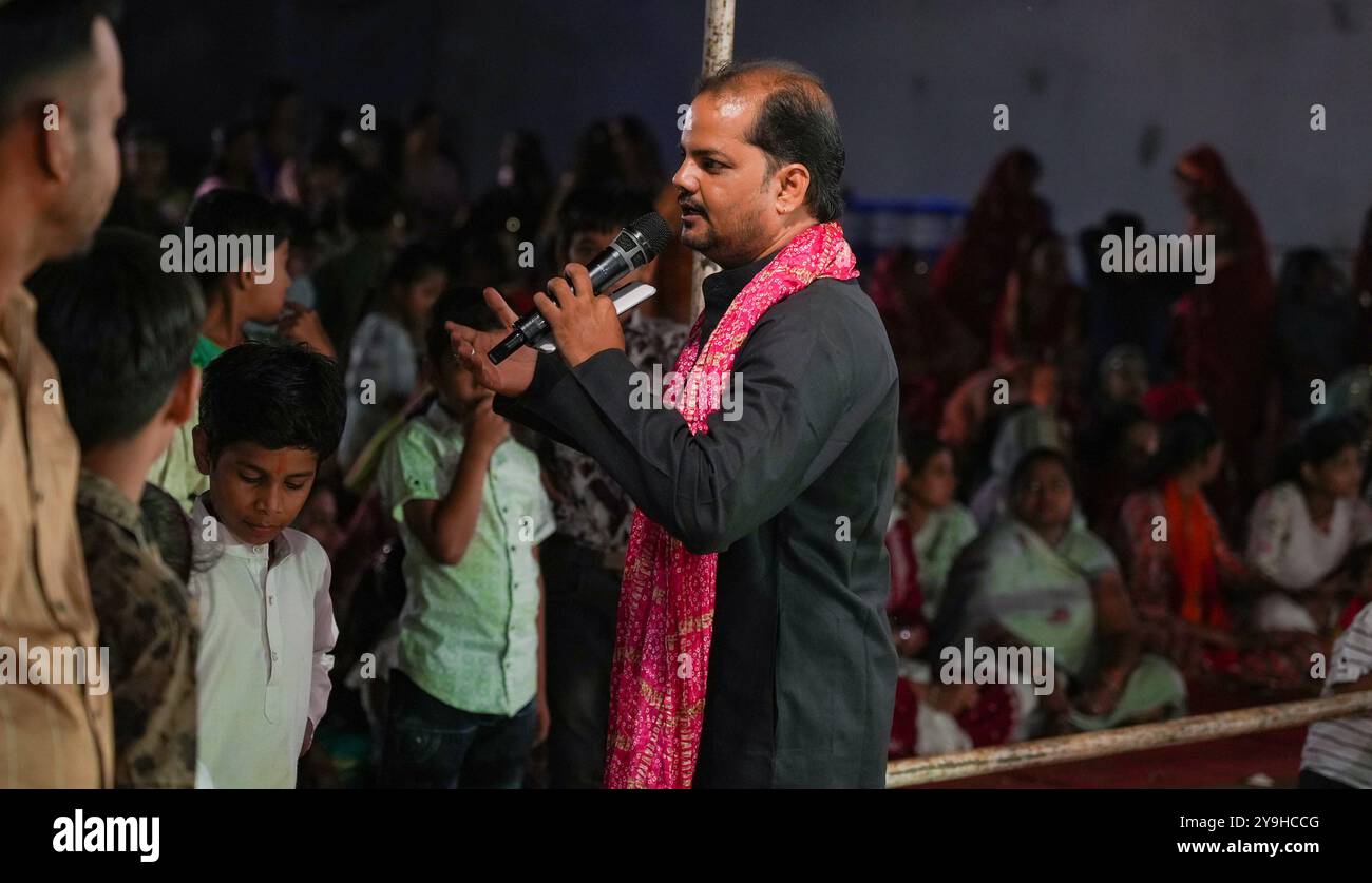 Beawar, Rajasthan, India, 9 ottobre 2024: Rajasthani man si rivolge alla folla mentre le donne eseguono la danza "garba" durante le celebrazioni del festival Navratri a Beawar. Crediti: Sumit Saraswat / Alamy Live News Foto Stock