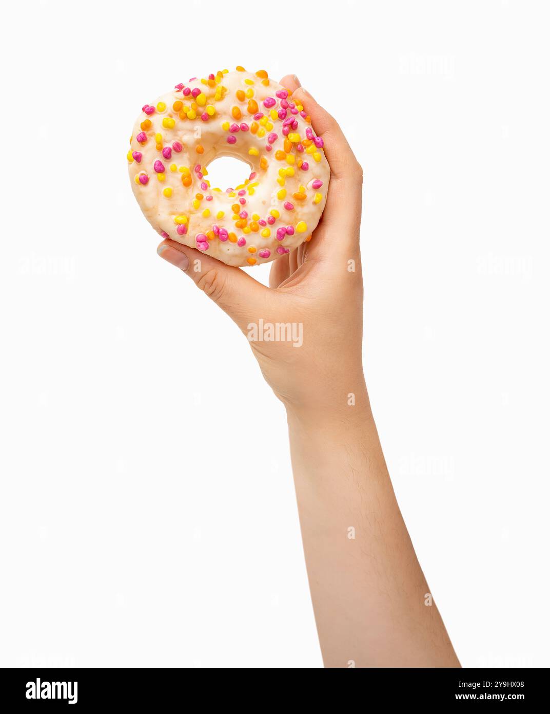Donna che tiene la ciambella al cioccolato bianco con spruzzi multicolore su sfondo bianco. Vista dall'alto, disposizione piatta. Concetto di dolce, dessert, dieta. Banner wi Foto Stock