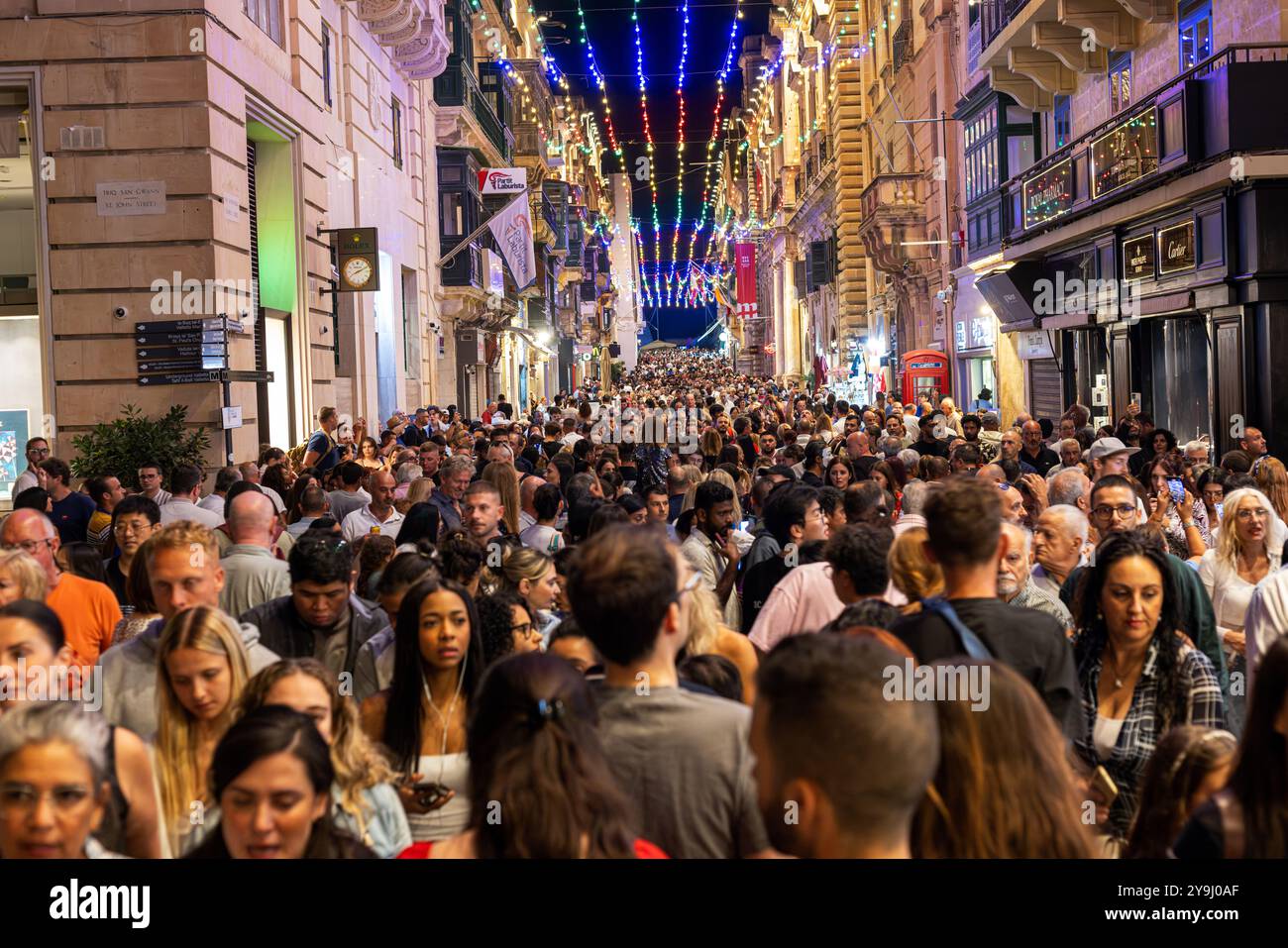 Il crepuscolo cade sulla Republic Street di la Valletta mentre la folla si riunisce per celebrare il festival notte Bianca. La scena vibrante mette in mostra l'atmosfera vivace, h Foto Stock