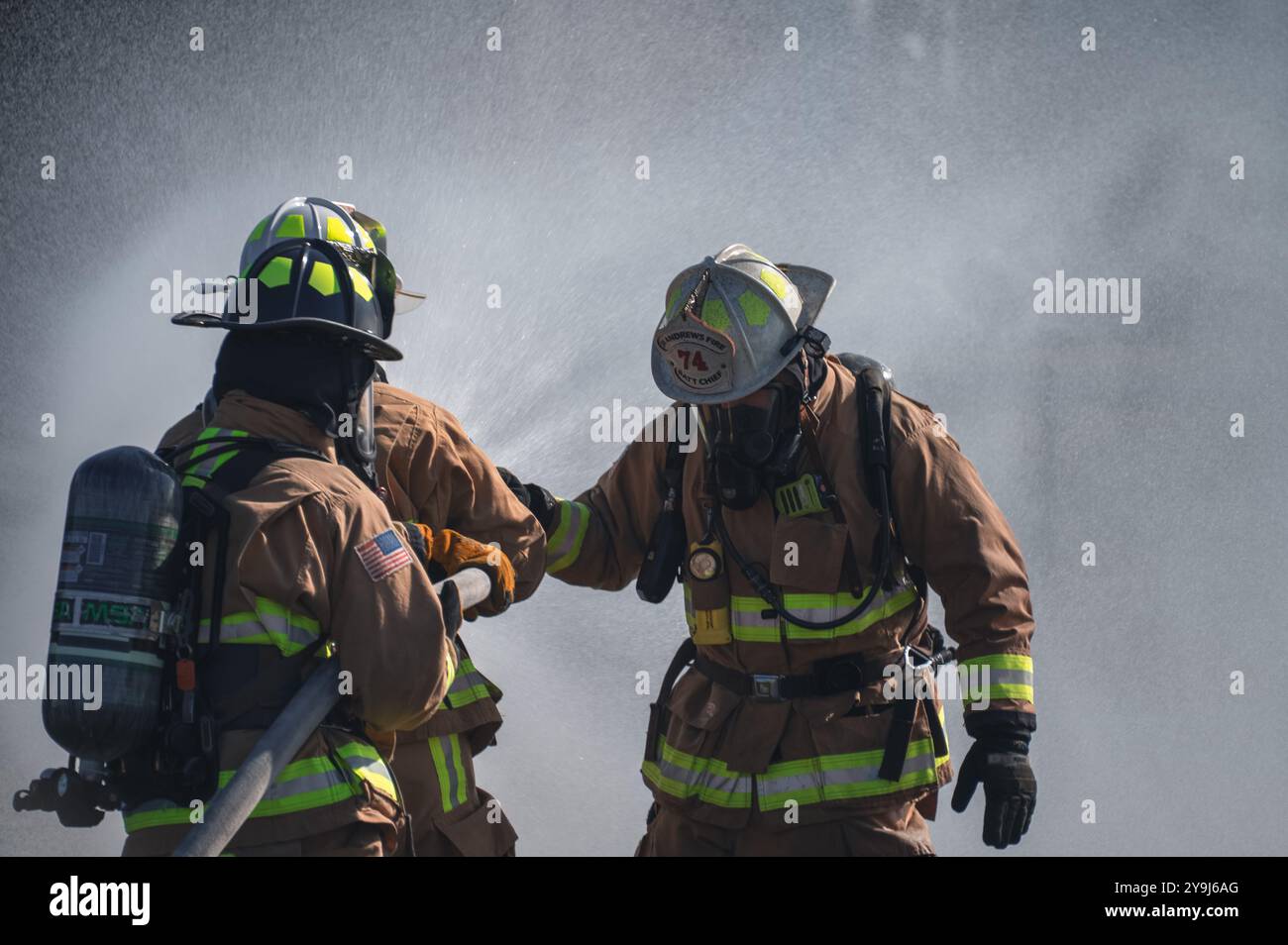 Da sinistra, il comandante dell'aeronautica statunitense Kevin W. Helms, capo del comando del 316th Wing, l'Airman senior Aaron Macedo, un vigile del fuoco assegnato al 316th Civil Engineer Squadron, e Michael Melson, capo del battaglione del CES 316, reprimere un incendio durante un'esercitazione di fuoco in diretta alla Joint base Andrews, MD, 7 ottobre 2024. Melson, l'istruttore di dinamica del fuoco, ha assistito Helms e Macedo nell'utilizzo della manichetta antincendio durante l'esercizio. (Foto U.S. Air Force di staff Sgt. Alex Broome) Foto Stock
