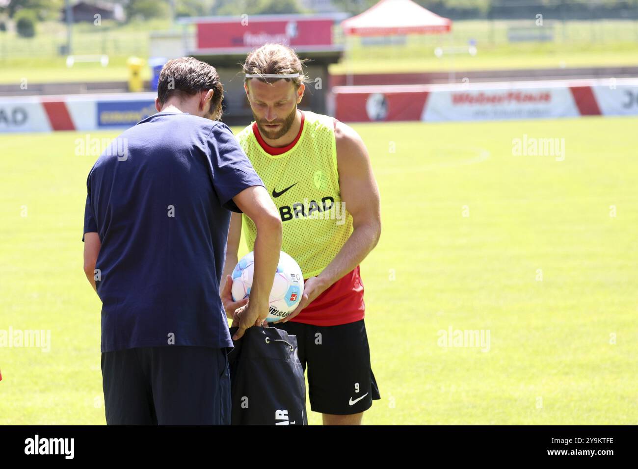 Il coach Julian Schuster (SC Freiburg) esemplifica lo spirito di squadra e aiuta Lucas Hoeler (SC Freiburg) a raccogliere palle dopo l'allenamento presso il SC Freiburg Schru Foto Stock