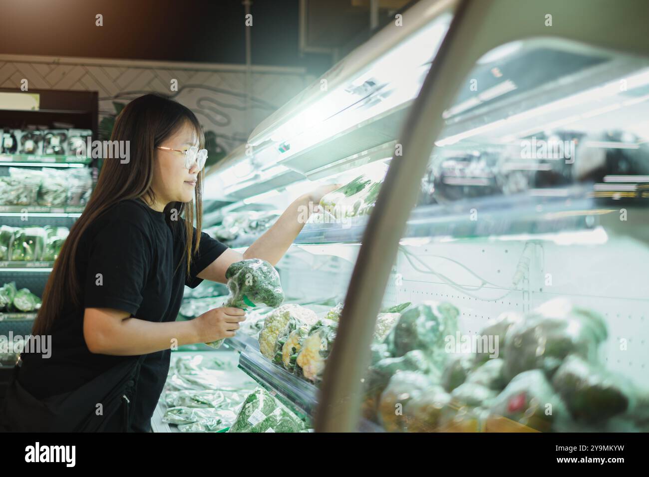 Una donna asiatica sta comprando verdure fresche da comprare in un supermercato Foto Stock