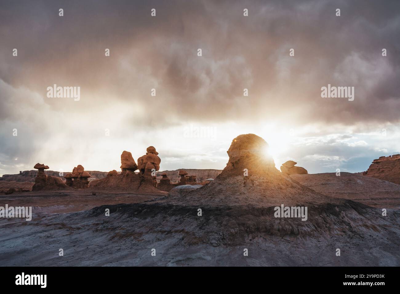 Il sole tramonta su Hoodoos nella Goblin Valley con Stormy Sky Foto Stock