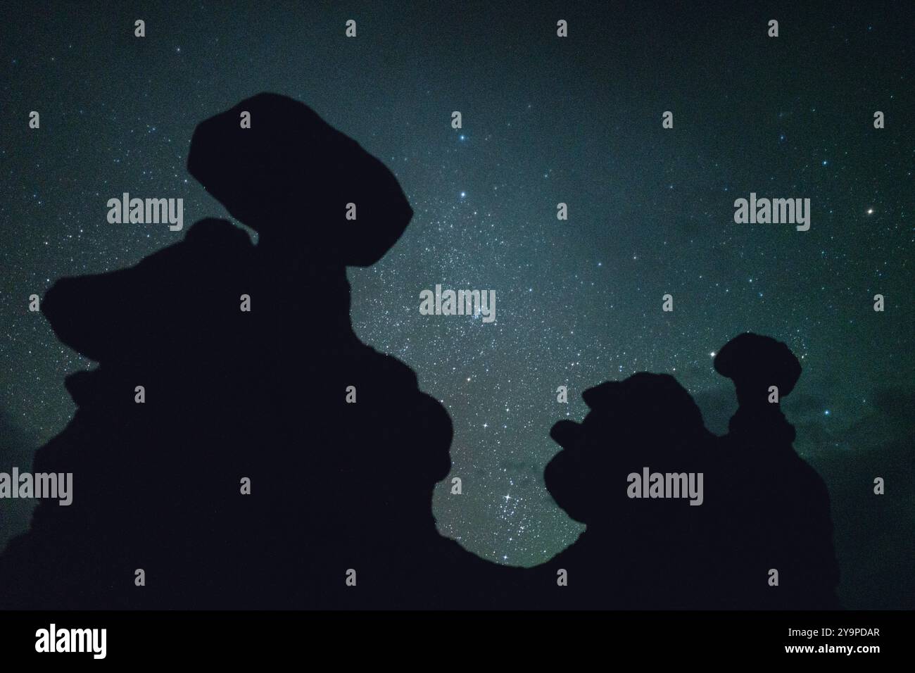 Cielo stellato notturno dietro la silhouette di Hoodoos in Un deserto Foto Stock