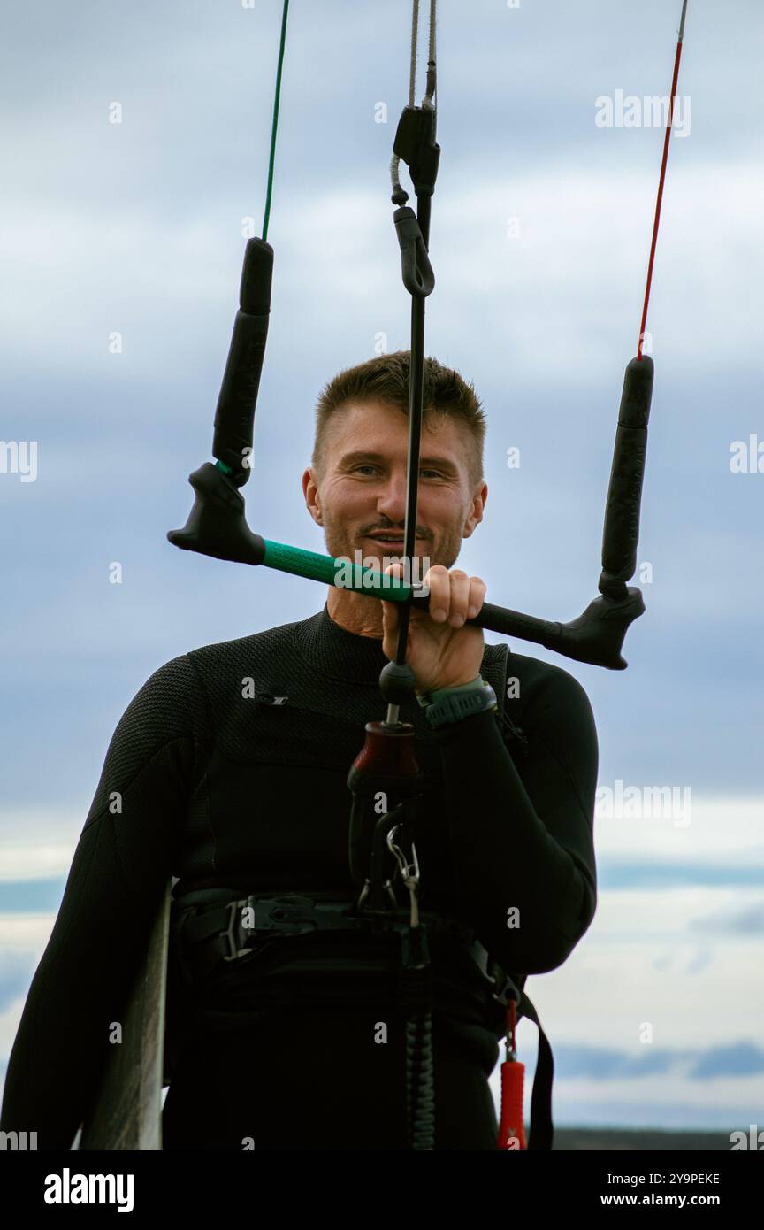 Uomo di mezza età kite surf, tenendo un bar tra le mani. Foto Stock