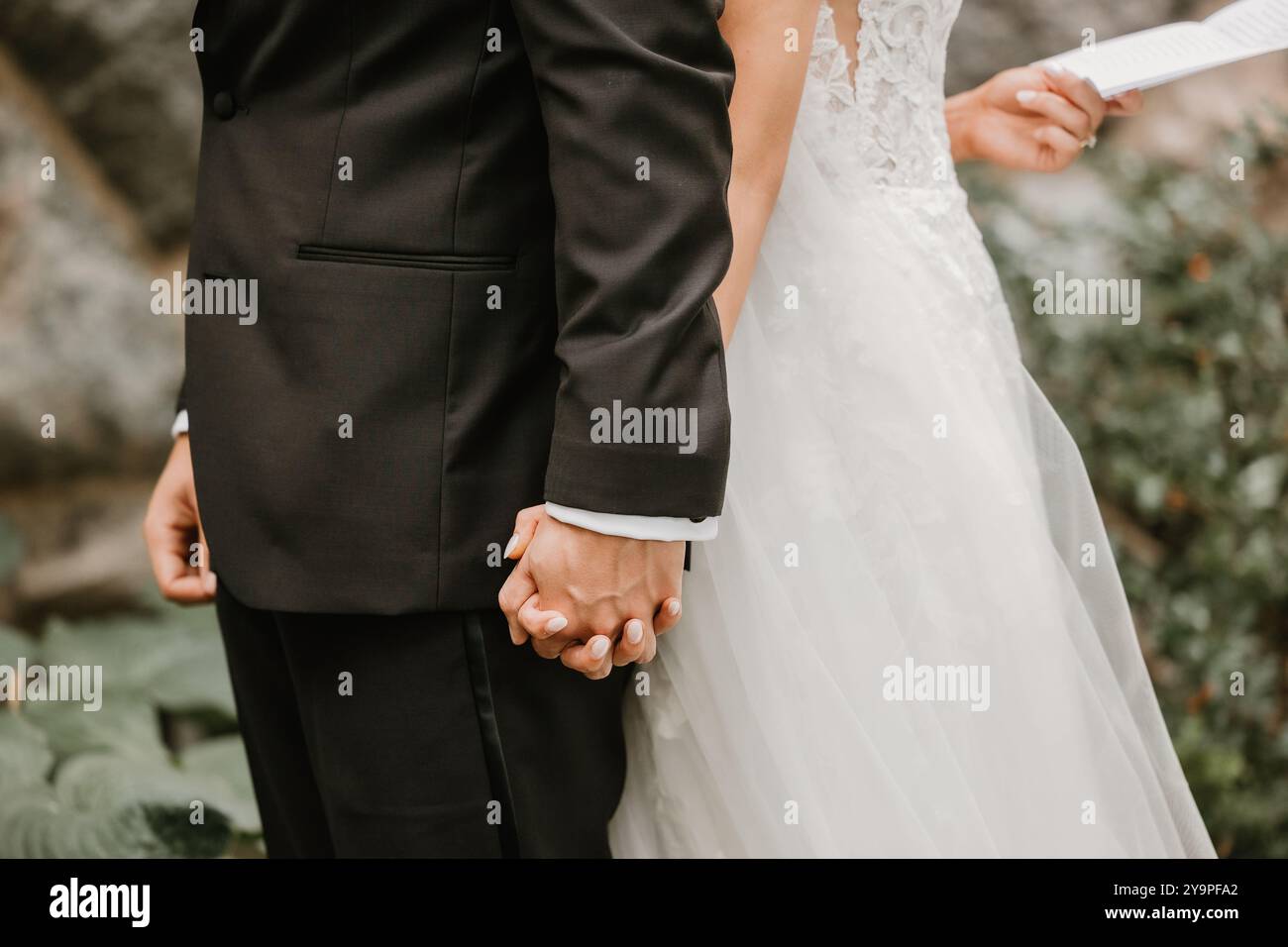 Sposa e sposo che si tengono per mano, scambiandosi le promesse Foto Stock