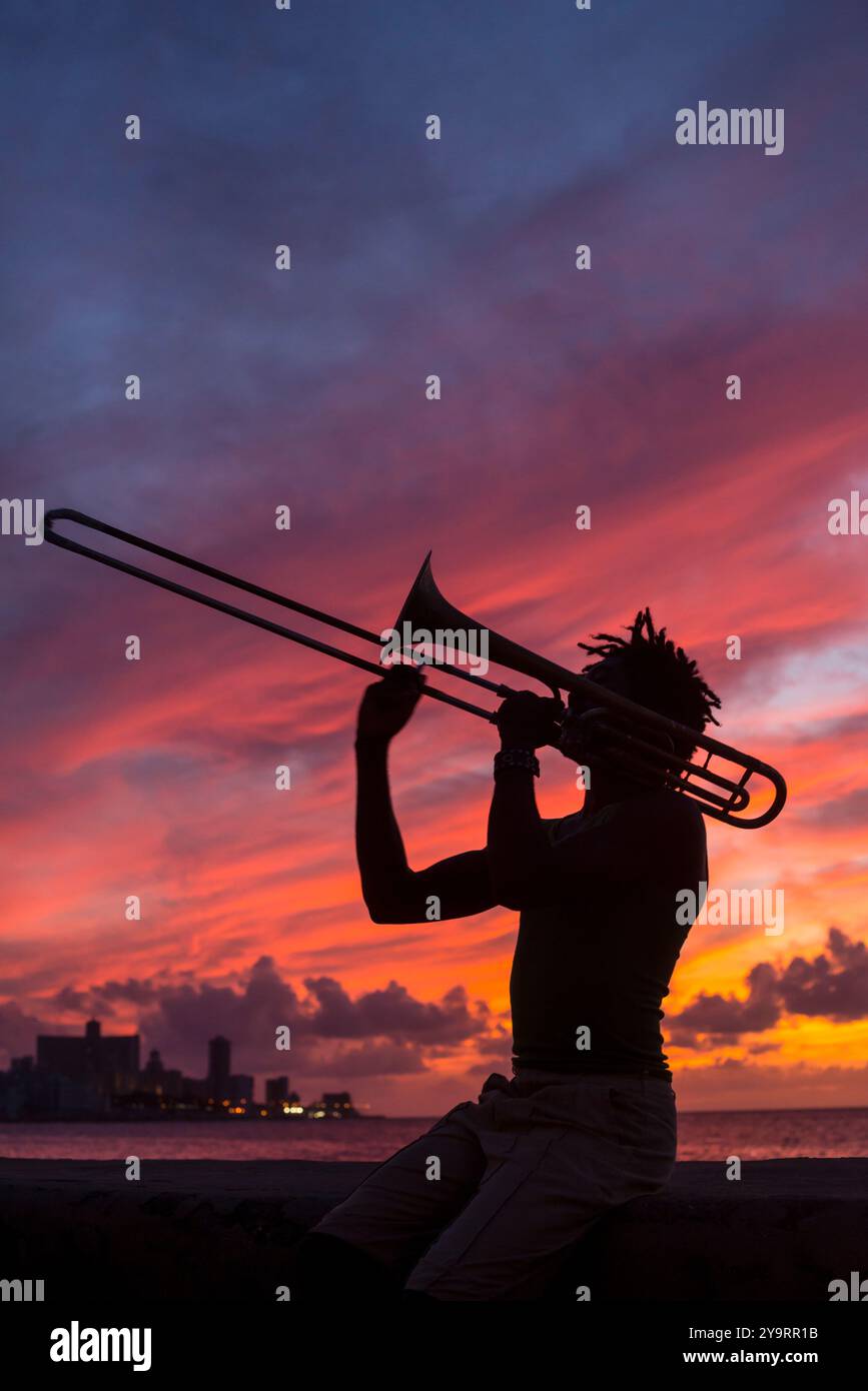 Uomo che suona la tromba per le strade, nella zona di Malecón a l'Avana, Cuba - foto di scorta Foto Stock