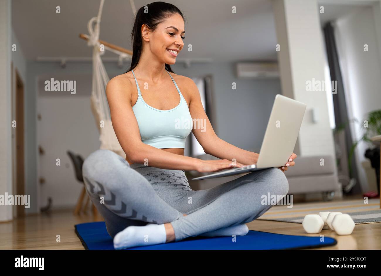 Ritratto di una bella donna sportiva, fitness girl che guarda video sul laptop durante l'allenamento Foto Stock