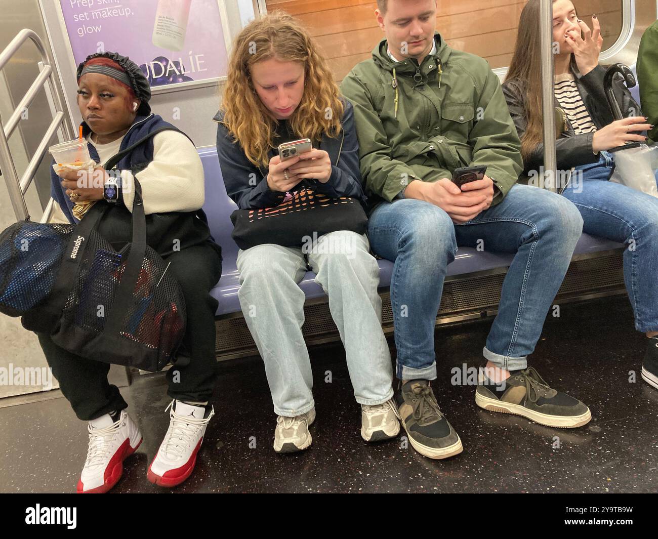 I passeggeri distratti su un treno affollato nella metropolitana di New York domenica 29 settembre 2024. (© Frances M. Roberts) Foto Stock