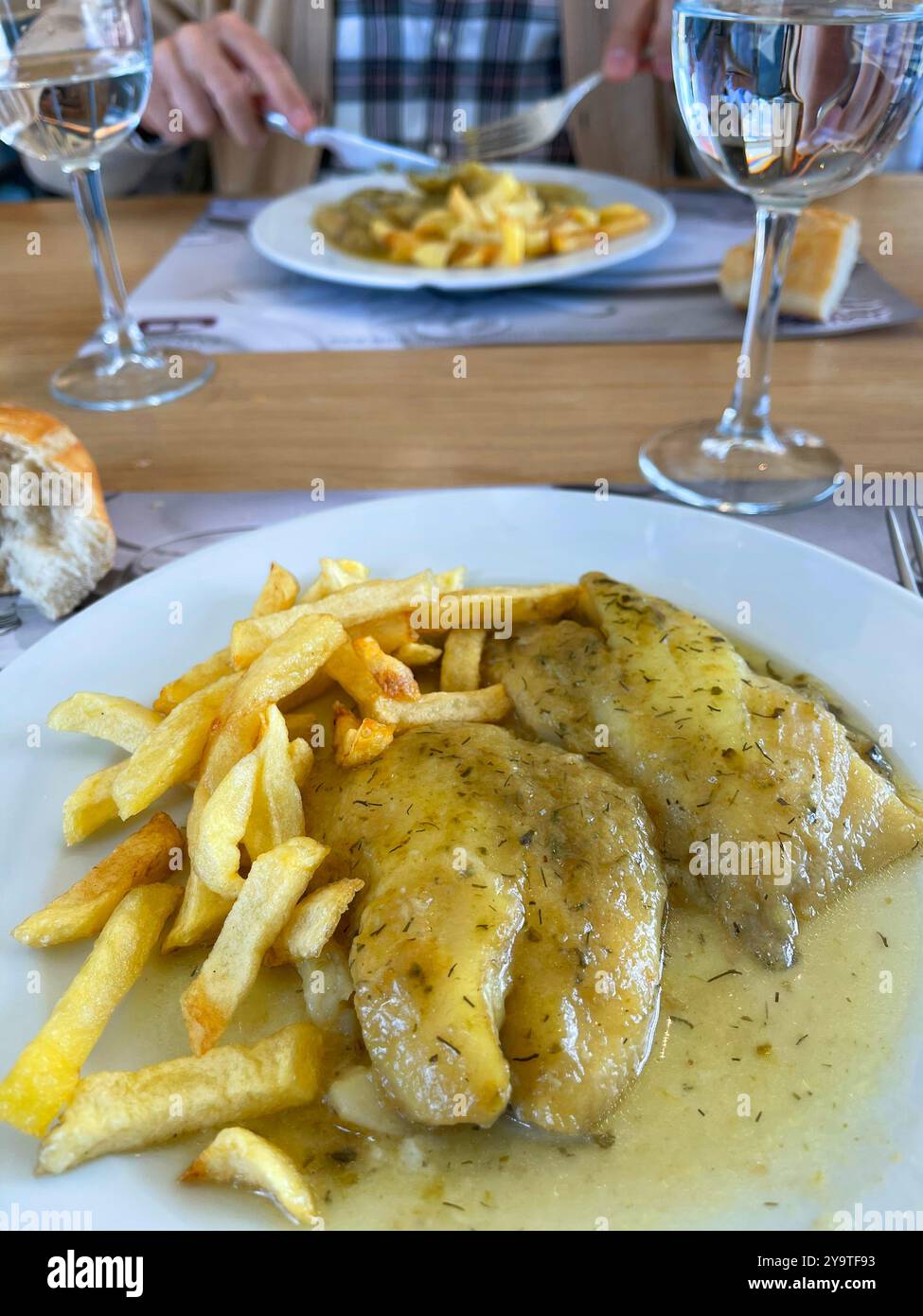 Mangiare lombo di nasello con salsa e patatine. Foto Stock