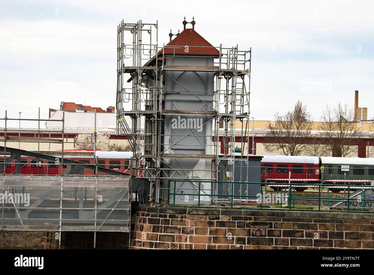 Deutschlands älteste Eisenbahnhubbrücke steht im Magdeburger Wissenschaftshafen. DAS historische Bauwerk erhält nun mit Unterstützung des Jobcenters frische Farbe. Dafür wurde extra eine Farbexpertin hinzugezogen, die mit Untersuchungen den genauen Farbton herausgefunden Hat, in dem die Hubbrücke zu ihrer Eröffnung 1894 angestrichen War. AM Steuerhäuschen kann man die neue Farbe bereits sehen. Teilnehmer einer Maßnahme des Jobcenters sind dafür verantwortlich, die unter fachmännischer Anleitung die notwendigen Arbeiten durchführen. SIE sollen so Fertigkeiten für die Rückkehr auf den Arbeitsmar Foto Stock