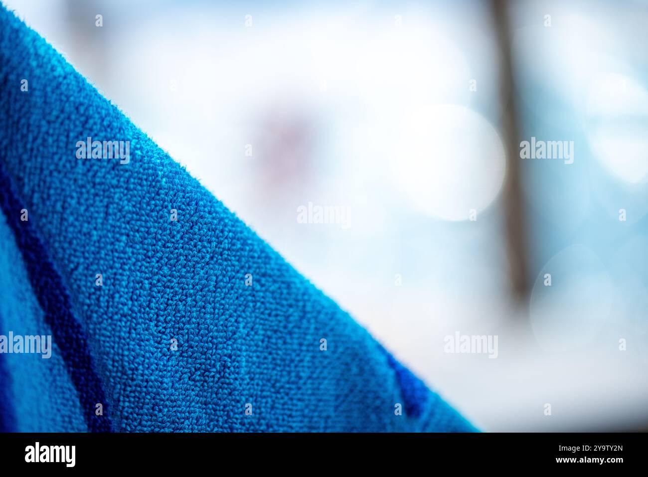 Una vista dettagliata di un asciugamano blu, che mostra la sua consistenza, tessitura e colori vivaci, perfetto per gli ambienti della spiaggia o del bagno. Foto Stock