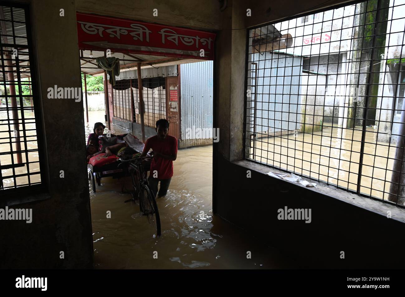 Persone che prendono trattamento in un ospedale governativo durante l'alluvione nel distretto di Feni, Bangladesh, il 25 agosto 2024 Foto Stock