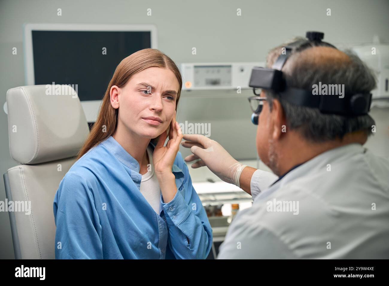 Medico adulto e paziente che discutono di condizioni dell'orecchio Foto Stock
