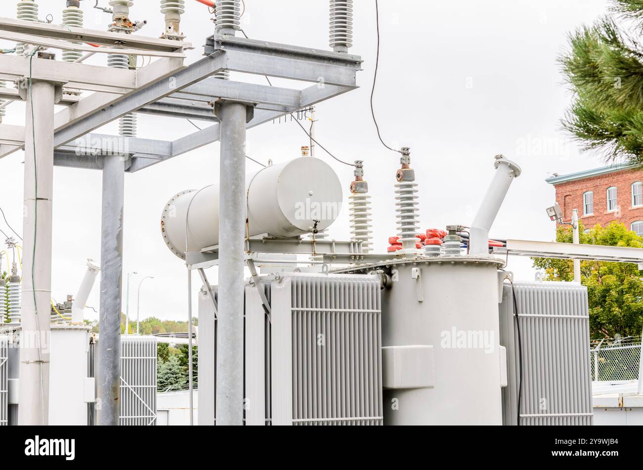 Dettaglio di un trasformatore elettrico in una sottostazione elettrica urbana in una giornata nuvolosa Foto Stock