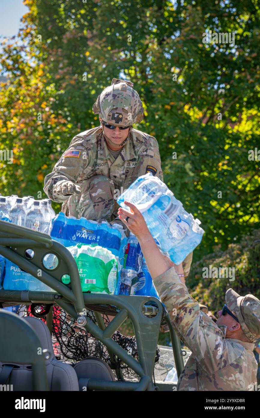 Hot Springs, Stati Uniti. 9 ottobre, 2024. I soldati dell'esercito americano con Task Force Castle caricano acqua in bottiglia sui veicoli per la distribuzione ai sopravvissuti dopo l'uragano Helene, il 9 ottobre 2024 a Hot Springs, Carolina del Nord. Crediti: Charles Delano/US Army Photo/Alamy Live News Foto Stock