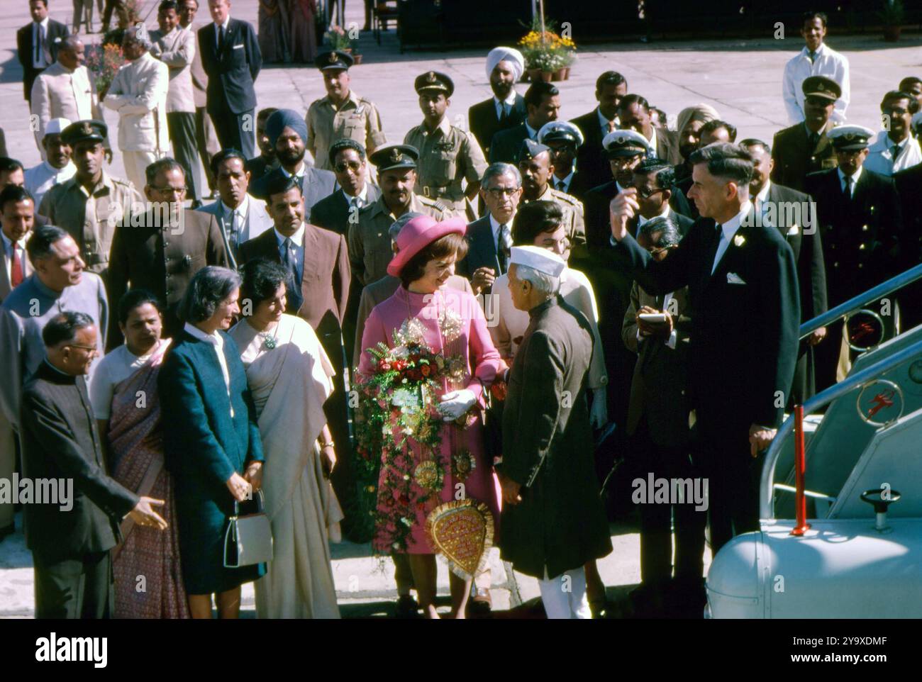 La First Lady statunitense Jacqueline Kennedy (al centro, con indosso rosa) viene accolta dal primo ministro indiano, Jawaharlal Nehru, al suo arrivo all'aeroporto di Palam, Delhi, India, Cecil Stoughton, fotografie della Casa Bianca, 12 marzo 1962 Foto Stock