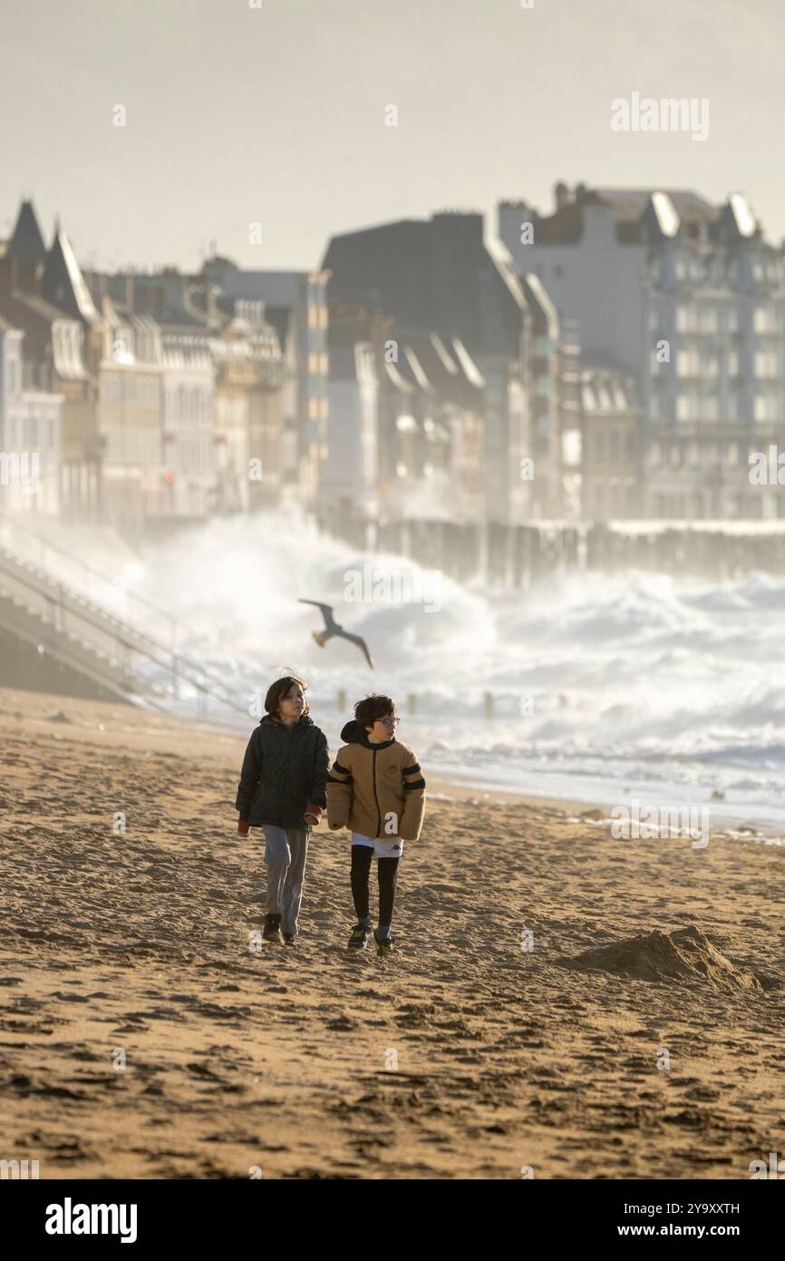 Francia, Ille-et-Vilaine, Saint-Malo, maree aspre al tramonto con persone in primo piano, Sillon Beach e splendide onde Foto Stock