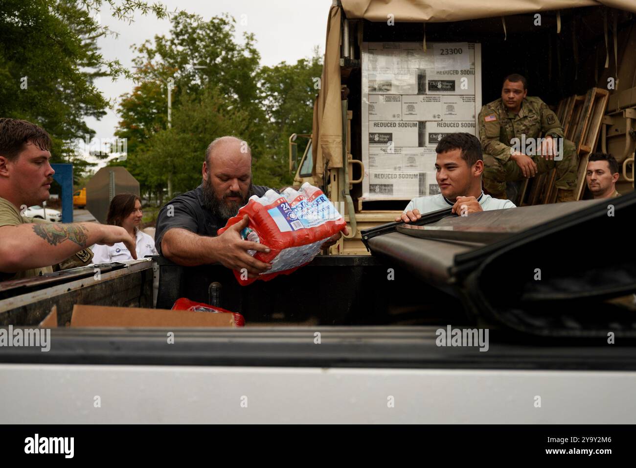 Hot Springs, Stati Uniti. 29 settembre 2024. I soldati dell'esercito americano con la Task Force Panther, insieme a volontari civili distribuiscono cibo e MREs ai sopravvissuti dopo l'uragano Helene alla William W. Estes Elementary School, il 30 settembre 2024 ad Asheville, Carolina del Nord. Crediti: Madeleine Cook/FEMA Photo/Alamy Live News Foto Stock