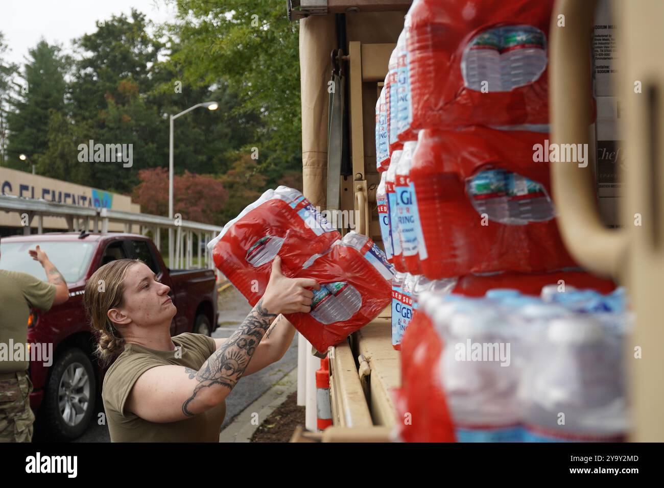 Hot Springs, Stati Uniti. 29 settembre 2024. I soldati dell'esercito americano con la Task Force Panther, insieme a volontari civili distribuiscono cibo e MREs ai sopravvissuti dopo l'uragano Helene alla William W. Estes Elementary School, il 30 settembre 2024 ad Asheville, Carolina del Nord. Crediti: Madeleine Cook/FEMA Photo/Alamy Live News Foto Stock