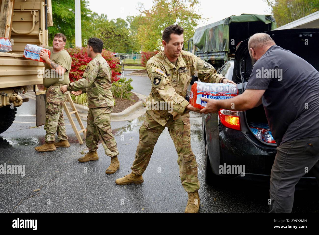 Hot Springs, Stati Uniti. 29 settembre 2024. I soldati dell'esercito americano con la Task Force Panther, insieme a volontari civili distribuiscono cibo e MREs ai sopravvissuti dopo l'uragano Helene alla William W. Estes Elementary School, il 30 settembre 2024 ad Asheville, Carolina del Nord. Crediti: Madeleine Cook/FEMA Photo/Alamy Live News Foto Stock