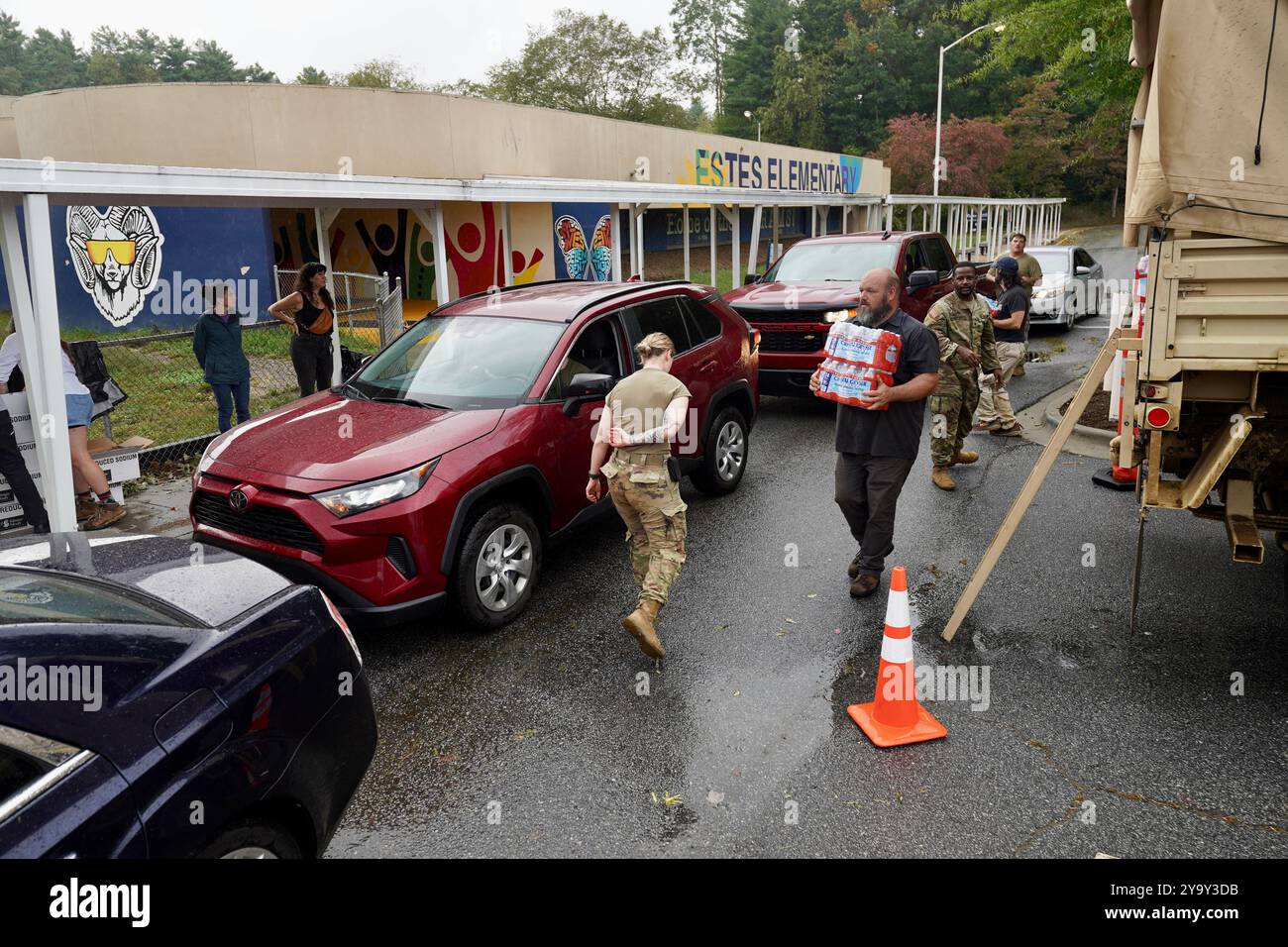 Hot Springs, Stati Uniti. 29 settembre 2024. I soldati dell'esercito americano con la Task Force Panther, insieme a volontari civili distribuiscono cibo e MREs ai sopravvissuti dopo l'uragano Helene alla William W. Estes Elementary School, il 30 settembre 2024 ad Asheville, Carolina del Nord. Crediti: Madeleine Cook/FEMA Photo/Alamy Live News Foto Stock
