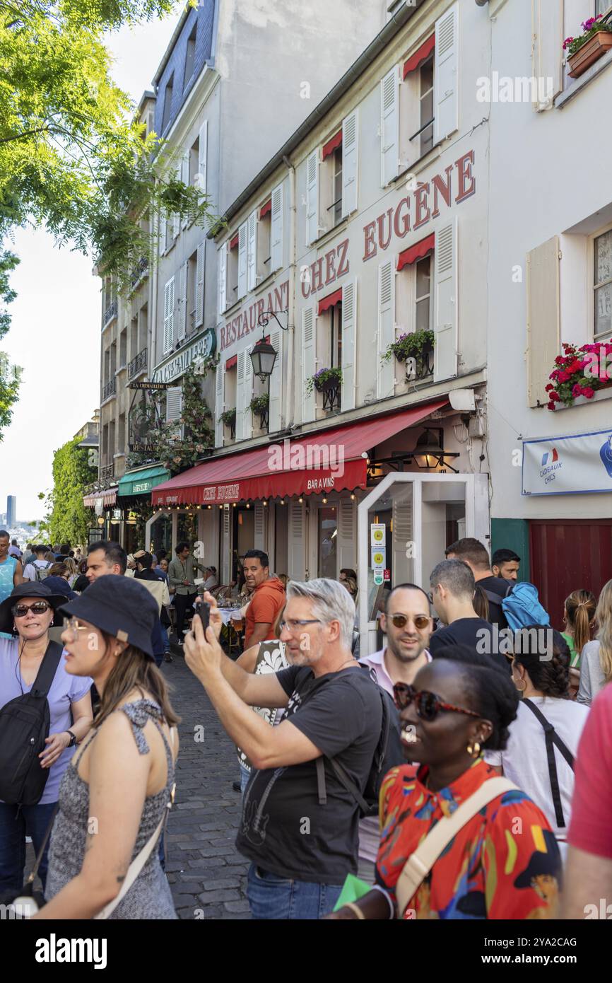 Vivace scena di strada con persone che scattano foto di fronte ai ristoranti di Parigi Foto Stock